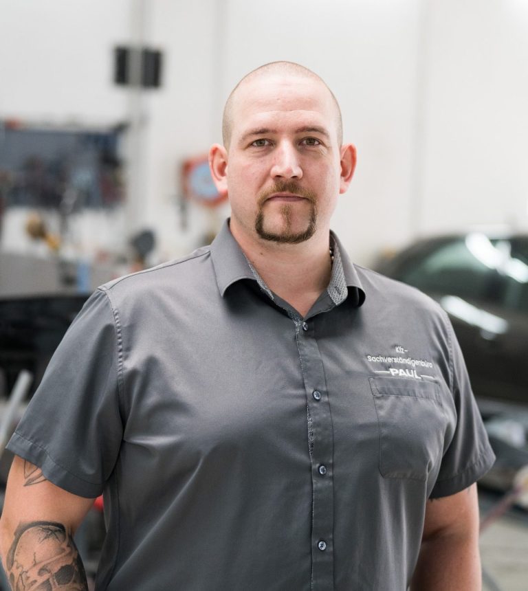 Jens Paul - Inhaber des Kfz-Sachverständigenbüro Paul Ein Mann mit kurzen Haaren und einem breiten Lächeln, trägt ein hellblaues Hemd.