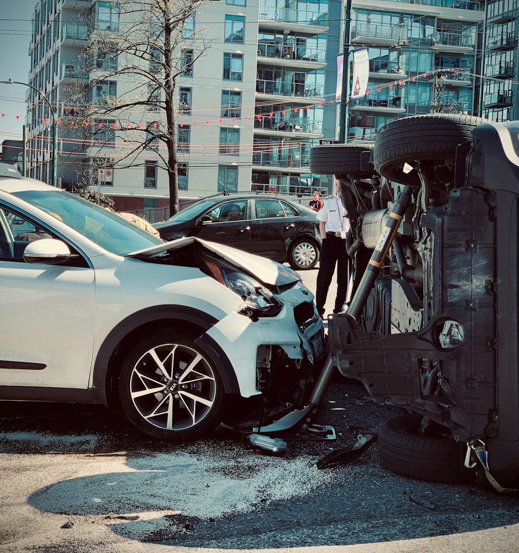 Autounfall mit zwei Fahrzeugen Zwei beschädigte Autos nach einem Unfall, eines ist auf die Seite gekippt.